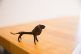 Side profile of a vintage African lion sculpture showing its textured, dark patina.