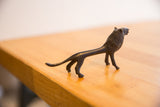 Elongated body and curved tail of the vintage handmade African lion sculpture.
