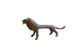 Vintage handmade African lion sculpture with an elongated body and dark patina finish.