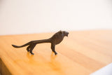 Side profile of the vintage lion sculpture showing its dark patina and slender body.