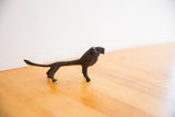 Vintage African lion sculpture in profile, highlighting its slender form and dark patina.