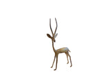 Vintage handmade African gazelle sculpture with a dark oxidized patina, facing left.