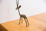 Side view of the vintage African gazelle sculpture showing its handmade oxidized surface.