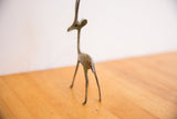 The handmade texture and time-softened patina on the back of a vintage gazelle sculpture.