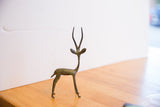 The vintage African gazelle's oxidized patina and slender, left-facing silhouette.