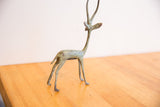 Left facing vintage African gazelle's head with stylized horns and green patina.