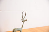 Vintage African left-facing gazelle head with slender horns and green patina.