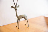 Vintage African gazelle sculpture showing its textured, oxidized finish and slender form.