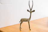 The slender form and textured green oxidized patina on a vintage African gazelle sculpture.