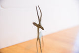 Close-up of vintage African gazelle sculpture, left-facing head and patinated horns.