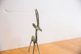 Side profile of the vintage gazelle sculpture highlighting its oxidized patina and long horns.