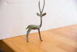 Profile view of a vintage African gazelle sculpture highlighting its oxidized patina.