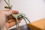 In-hand profile of a vintage African gazelle showing its slender form and oxidized patina.