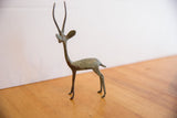 Vintage gazelle sculpture showing its slender form and oxidized patina from the right side.