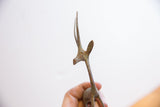 Detail of the handmade texture and oxidized patina on a vintage gazelle sculpture's head.