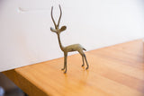 Side profile of a right-facing vintage African gazelle sculpture showing its oxidized patina.