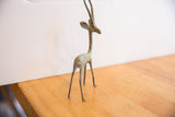 Three-quarter view of the slender vintage African gazelle sculpture, showing its oxidized patina.
