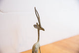 Angled view of the vintage African gazelle sculpture's head and slender horns.