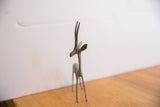 Right facing vintage African gazelle sculpture's head, long horns, and aged patina.
