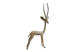 Vintage African right-facing gazelle sculpture with aged metallic patina.