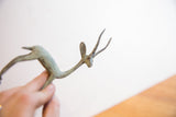 Close-up of the vintage African gazelle sculpture's head and long, textured horns.