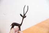 Angled view of the vintage gazelle's slender neck and head, showing its dark handmade patina.