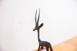 Profile view of the vintage gazelle's head showing its dark patina and slender horns.