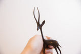 Handmade African gazelle sculpture with dark patina held to show its scale.