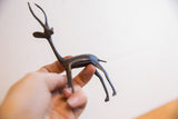 Vintage African gazelle figurine with a dark patina held to show its scale.