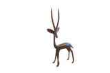 Vintage African gazelle sculpture with a dark aged patina, facing to the left.