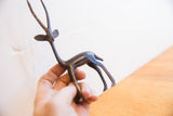 Vintage African gazelle sculpture with a dark patina held in hand to show its scale.