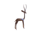 Handmade vintage African gazelle sculpture with a dark patina, facing right.