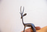 Sleek dark patina on the head and elegant horns of a vintage African gazelle figurine.