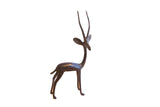 Vintage African gazelle figurine facing right, with a dark aged patina and slender, tall horns.