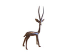 Vintage handmade African gazelle sculpture with a dark patina and tall elegant horns.