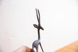 Close view of the gazelle sculpture's head, showing its dark patina and long horns.