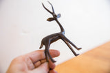 Handmade African gazelle figurine held, showing its delicate profile and dark patina.