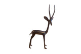 A vintage handmade African gazelle sculpture with a slender body and a dark patina.