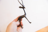 Angled view of the vintage African gazelle sculpture held in hand for scale.