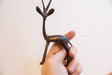 Vintage African gazelle sculpture with dark patina held in hand for scale.