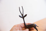 Vintage African gazelle sculpture with dark patina held in hand to show scale.