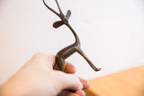 The handmade form of a small African gazelle sculpture held in hand.