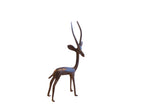 Vintage African gazelle sculpture standing and facing right with a dark aged patina.