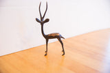 Vintage African gazelle sculpture in profile, showing its slender form and aged patina.