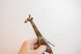 Vintage African giraffe sculpture held in hand to show its scale and patina.