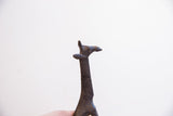 Dark patina and carved details on the head of a vintage giraffe sculpture.