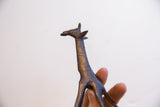 Close view of the vintage giraffe sculpture's carved neck and head with dark patina.