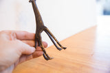 The dark, time-worn patina on the legs of a handmade African giraffe sculpture.