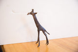 Side profile of the vintage African giraffe showing its handmade texture and dark aged patina.