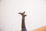 Close view of the vintage giraffe sculpture's head, showing the handmade texture and dark patina.